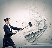 Frau haut auf Tastatur mit Hammer